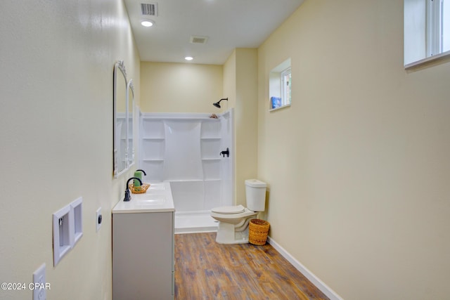 bathroom featuring toilet, walk in shower, vanity, and hardwood / wood-style floors