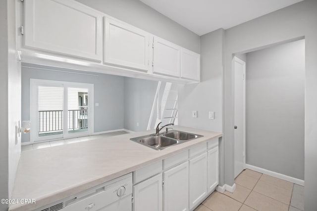 kitchen featuring dishwashing machine, white cabinetry, light countertops, and a sink