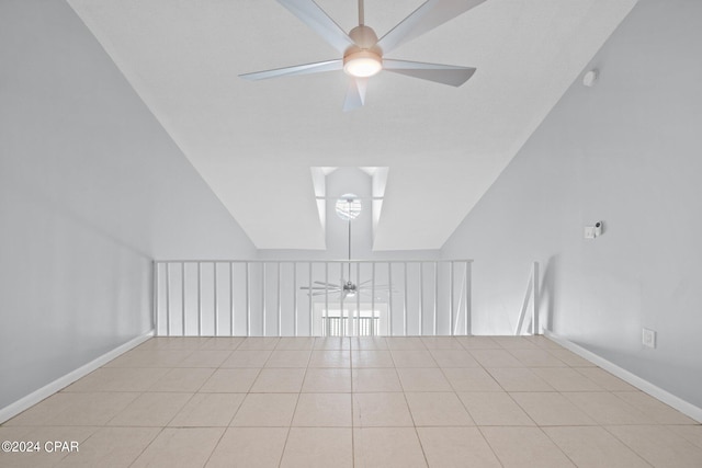 tiled spare room featuring a ceiling fan, lofted ceiling, and baseboards