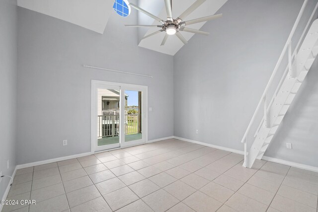 tiled spare room with high vaulted ceiling and ceiling fan