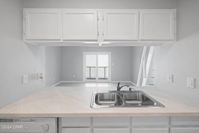 kitchen with white cabinets, kitchen peninsula, and sink