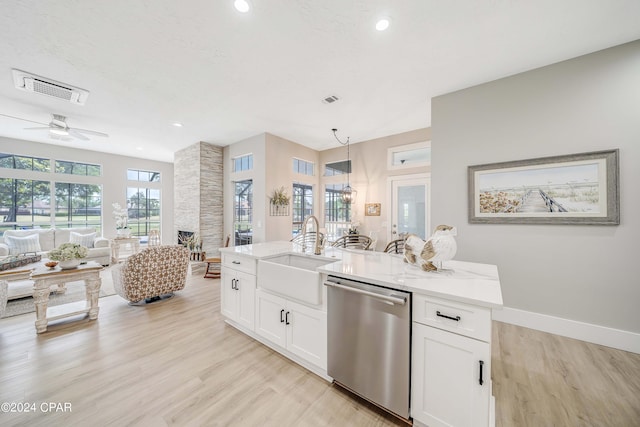 kitchen with light wood-type flooring, open floor plan, dishwasher, and a sink