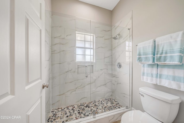 full bath featuring toilet and a marble finish shower