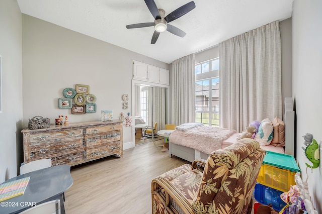 bedroom with light wood-type flooring, baseboards, and a ceiling fan