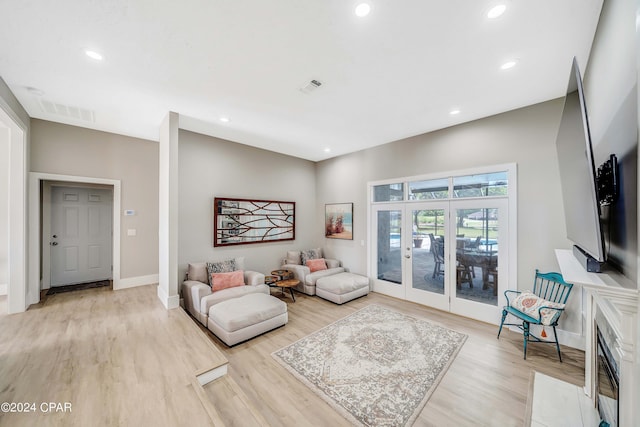 living room featuring light wood-style floors, recessed lighting, visible vents, and baseboards