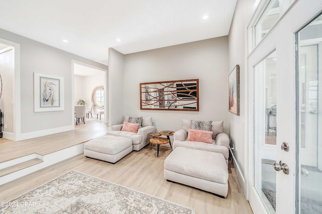 living room with light wood-style floors, recessed lighting, and baseboards