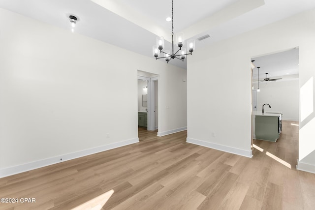 interior space featuring ceiling fan with notable chandelier, light hardwood / wood-style floors, and sink