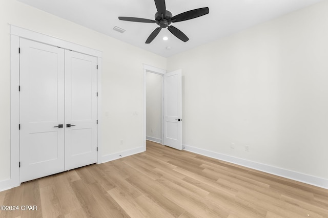 unfurnished bedroom featuring ceiling fan, a closet, and light hardwood / wood-style floors