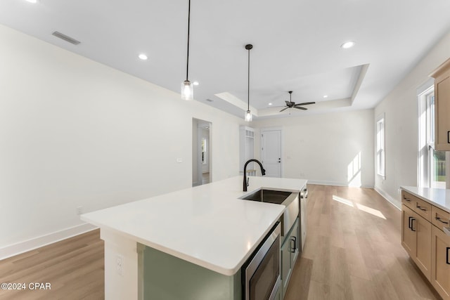 109 Johns Island Way, Panama City Beach, FL 32407 - kitchen featuring a raised ceiling, stainless steel microwave, light countertops, light wood finished floors, and recessed lighting
