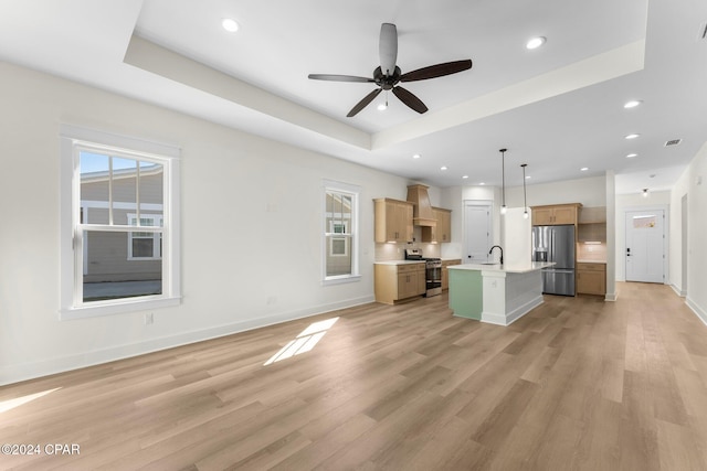 kitchen with a healthy amount of sunlight, pendant lighting, an island with sink, and stainless steel appliances