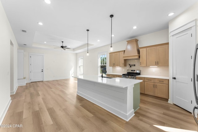 109 Johns Island Way, Panama City Beach, FL 32407 - kitchen featuring gas range, premium range hood, a ceiling fan, backsplash, and a tray ceiling