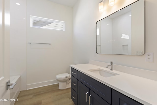 bathroom featuring vanity, wood finished floors, toilet, and baseboards