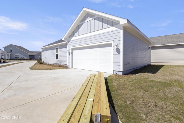 view of property exterior with board and batten siding, concrete driveway, and a garage