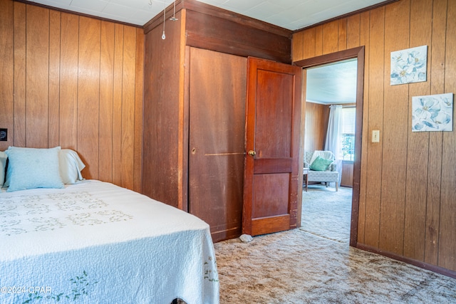 carpeted bedroom featuring wooden walls