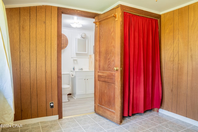 interior space featuring hardwood / wood-style floors, vanity, ornamental molding, and toilet