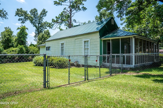 view of home's exterior featuring a sunroom and a yard