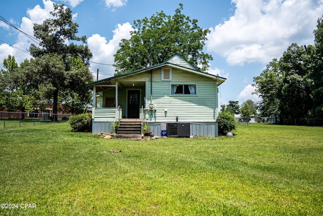 back of property featuring central AC and a lawn