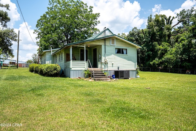 back of property with cooling unit and a lawn