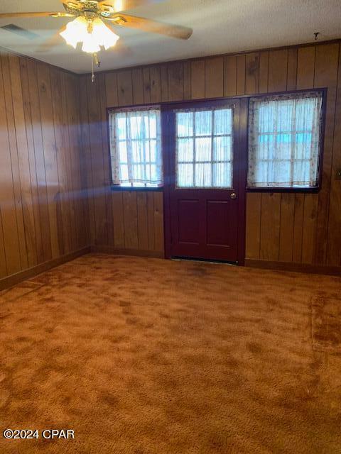 4908 Davis Dr, Marianna, FL 32446 - entryway featuring carpet flooring, ceiling fan, and wood walls