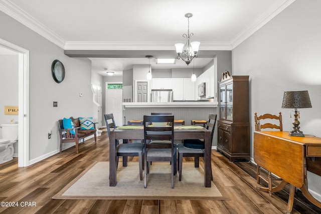 dining area with hardwood / wood-style floors, a notable chandelier, and ornamental molding