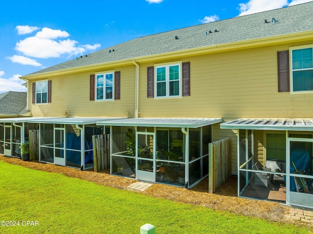 back of property featuring a yard and a sunroom