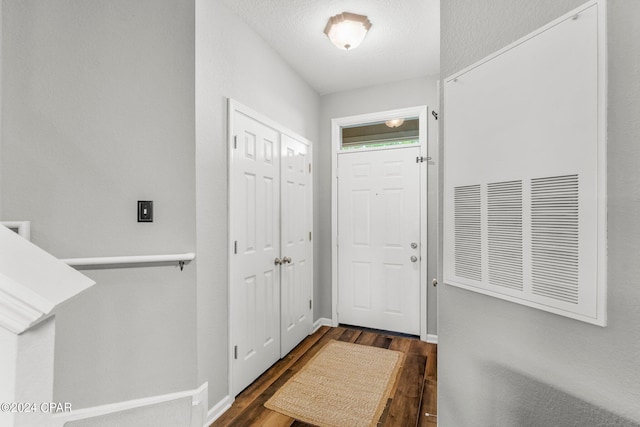 foyer featuring a textured ceiling and dark wood-type flooring