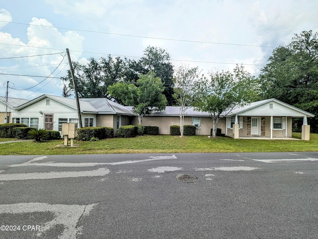 single story home featuring covered porch and a front lawn