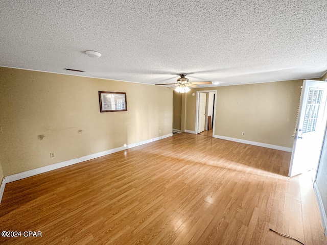 spare room featuring hardwood / wood-style flooring, ceiling fan, and a textured ceiling