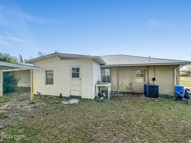 back of house with central AC and a yard