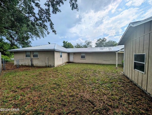 back of house with a lawn