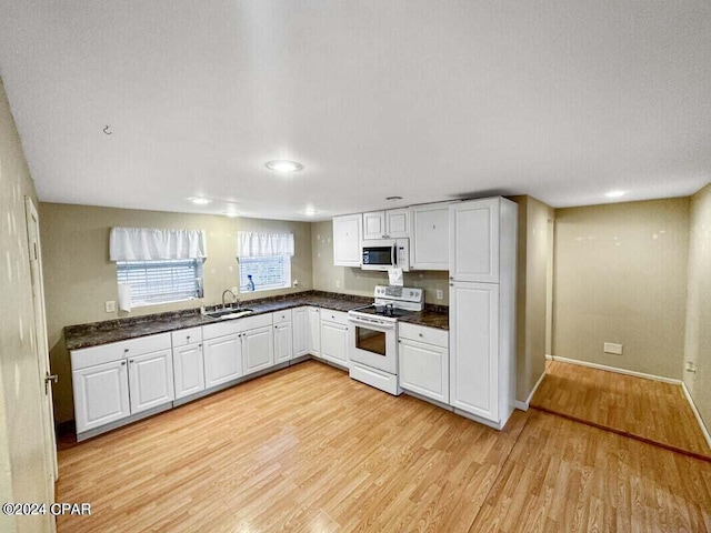 kitchen with white cabinets, light hardwood / wood-style floors, white appliances, and sink