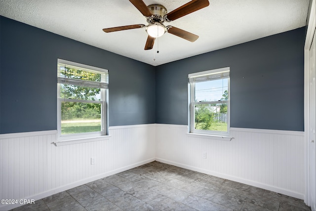 empty room featuring a textured ceiling and ceiling fan