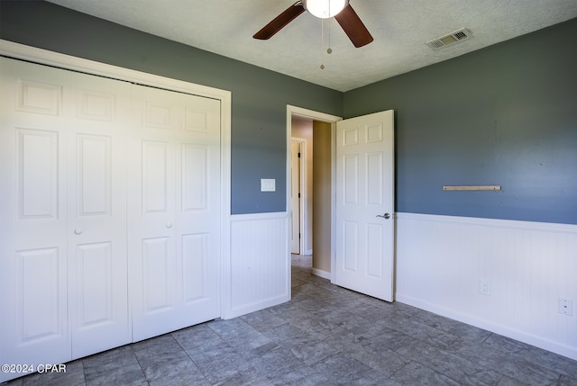 unfurnished bedroom featuring a closet, a textured ceiling, and ceiling fan