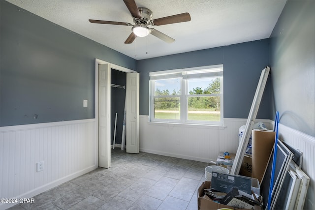 bedroom with a closet, a textured ceiling, and ceiling fan