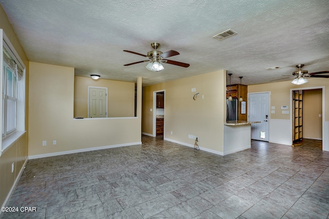 spare room with ceiling fan and a textured ceiling