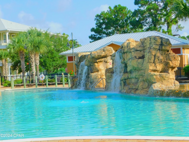 view of swimming pool with pool water feature