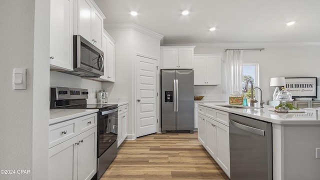 kitchen with ornamental molding, stainless steel appliances, sink, light hardwood / wood-style flooring, and white cabinets