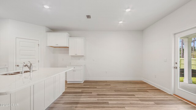 kitchen with light hardwood / wood-style floors, an island with sink, and stainless steel appliances