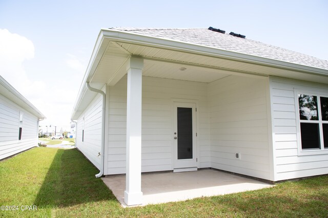 doorway to property featuring a patio area and a yard