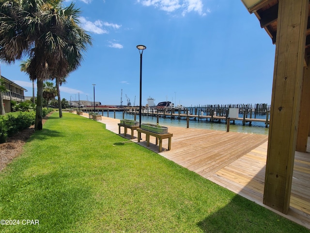 dock area with a water view and a yard