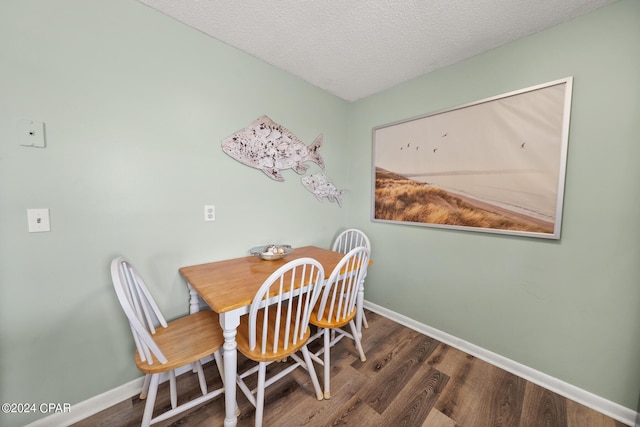 dining room featuring dark hardwood / wood-style floors and a textured ceiling