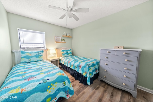 bedroom featuring ceiling fan, wood-type flooring, and a textured ceiling