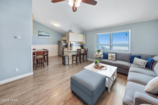 living room featuring ceiling fan, vaulted ceiling, and light hardwood / wood-style flooring