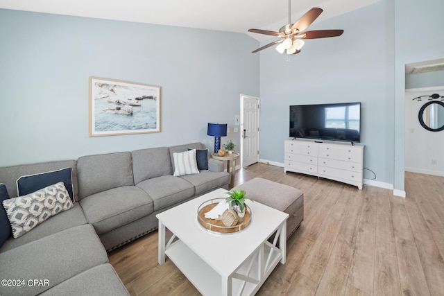 living room featuring high vaulted ceiling, ceiling fan, and light wood-type flooring