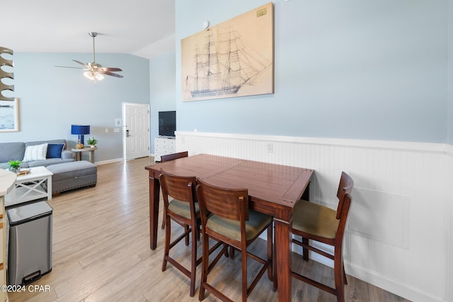 dining room with ceiling fan, lofted ceiling, and light hardwood / wood-style flooring