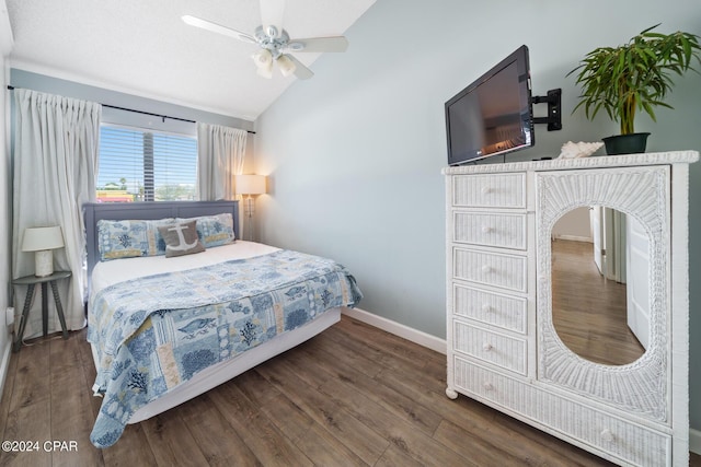 bedroom featuring ceiling fan, dark hardwood / wood-style flooring, and vaulted ceiling