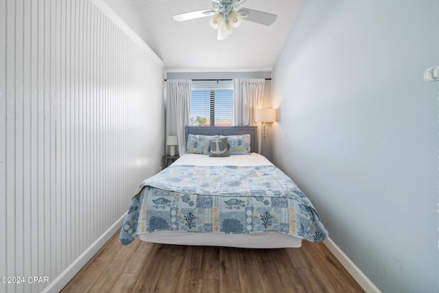 bedroom featuring ceiling fan, hardwood / wood-style floors, and a textured ceiling