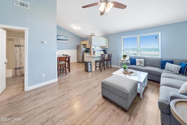 living room featuring vaulted ceiling, ceiling fan, and light wood-type flooring