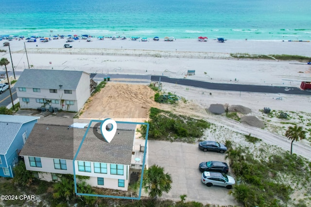 birds eye view of property with a water view and a beach view