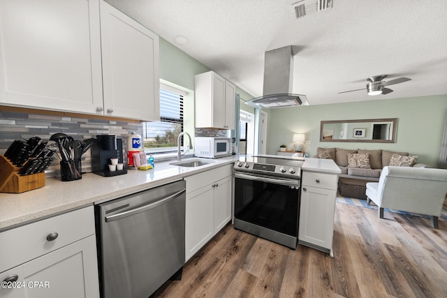 kitchen featuring sink, appliances with stainless steel finishes, dark hardwood / wood-style floors, island range hood, and white cabinets